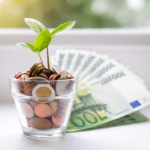 biljka koja raste iz čaše sa novcem simbolizuje rast investicija i ulaganje u investicione fondove