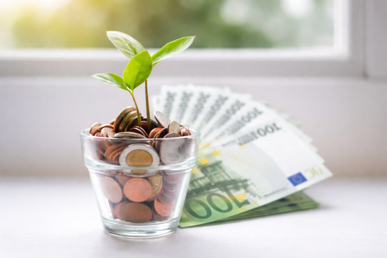 biljka koja raste iz čaše sa novcem simbolizuje rast investicija i ulaganje u investicione fondove